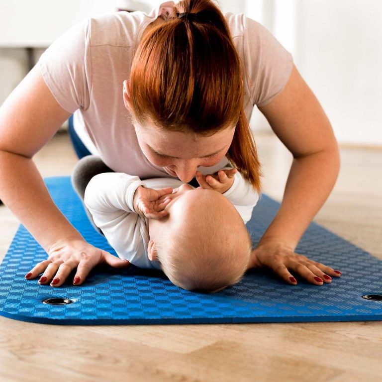 Baby mit Mama auf einer Trainingsmatte